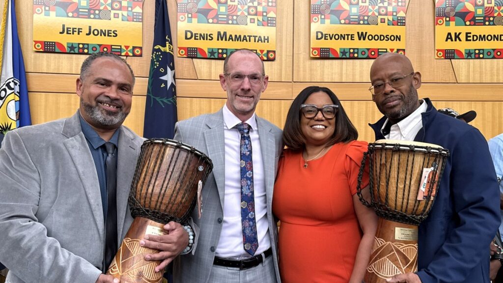 Commissioner Justin Jones (second from left) stands with Denis Mamattah during the recognition ceremony.